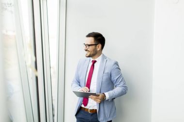 Office penceresinde tarafından tablet ile genç işadamı