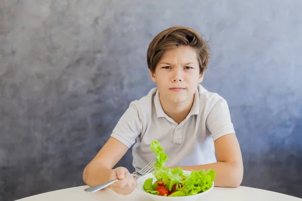 Милый подросток ест салат. — стоковое фото