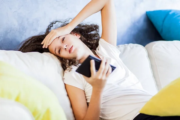 Tiener meisje rusten en usiing digitale tablet op de sofa thuis — Stockfoto