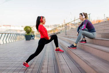 Genç kadın dışında kişisel bir eğitmen ile egzersiz