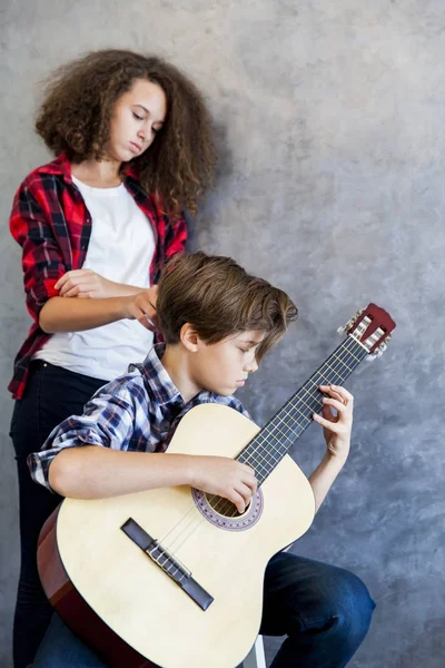 Teen ragazzo giocare acustica chitarra mentre teen ragazza ascoltando lui — Foto Stock