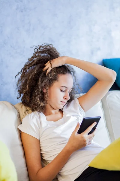 Teen κορίτσι ανάπαυσης και usiing ψηφιακό tablet στον καναπέ στο σπίτι — Φωτογραφία Αρχείου