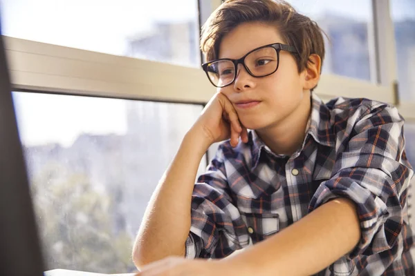 Teen pojke med laptop genom fönster — Stockfoto