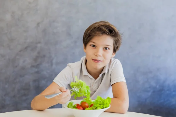 Adolescente chico comer ensalada — Foto de Stock