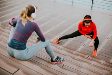 Genç kadın dışında kişisel bir eğitmen ile egzersiz