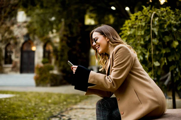 Mujer moderna usando el teléfono móvil en otoño — Foto de Stock