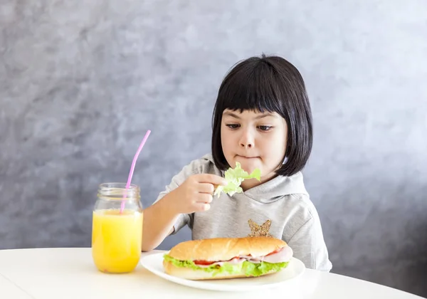 Retrato de una niña desayunando en casa — Foto de Stock