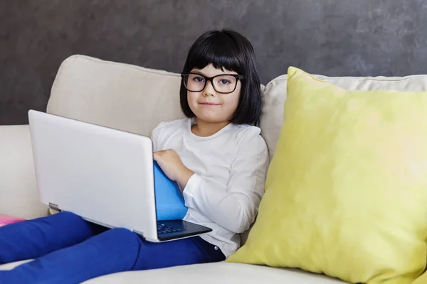 Niña con ropa casual usando un portátil mientras está sentada en tan — Foto de Stock