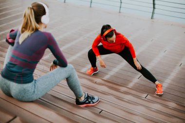 Genç kadın dışında kişisel bir eğitmen ile egzersiz