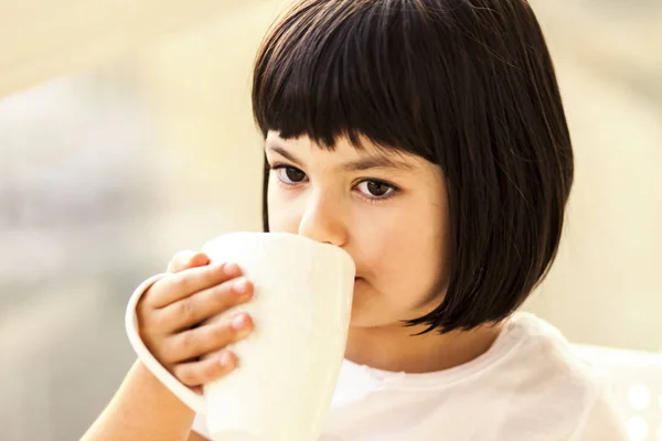 Niña bebiendo leche o té — Foto de Stock
