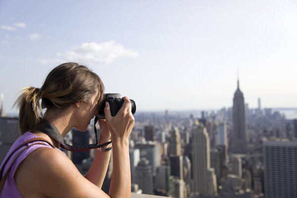 NEW YORK, USA - AUGUST 30, 2017: Young woman teking photo from Top of the Rock in New York, United States