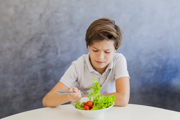 Lindo adolescente chico comer ensalada — Foto de Stock