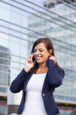 Genç bir kadın cep telefonuyla konuşuyor.