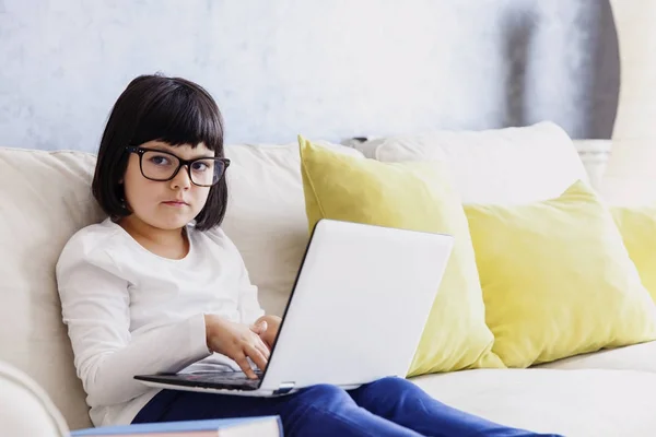 小女孩在休闲的衣服使用笔记本电脑, 而坐在这样 — 图库照片