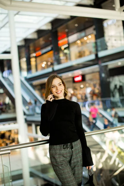 휴대 전화에 대 한 얘기는 쇼핑몰에서 젊은 여자 — 스톡 사진