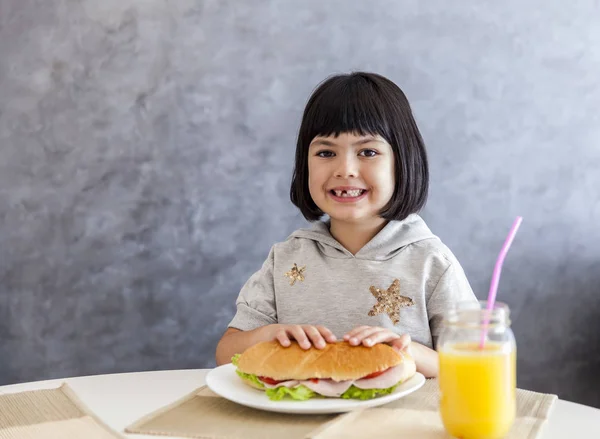 Retrato de una niña desayunando en casa — Foto de Stock