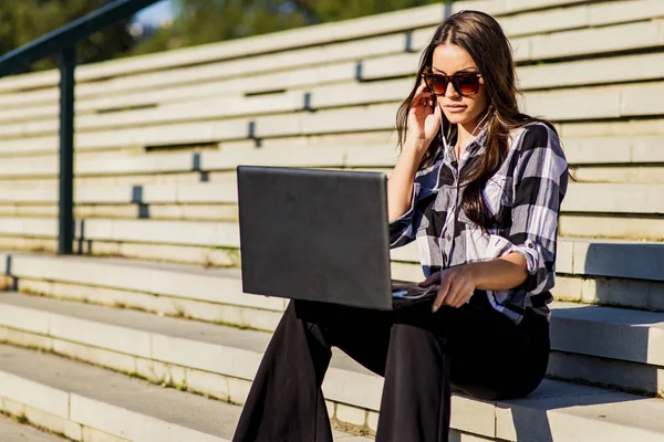 Jonge vrouw met laptop bij buiten trappen — Stockfoto