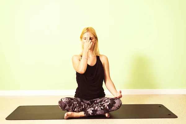 Beautiful young woman sitting in yoga position Stock Picture