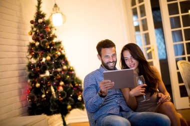 Genç tablet ile yeni yıl arifesinde çift.