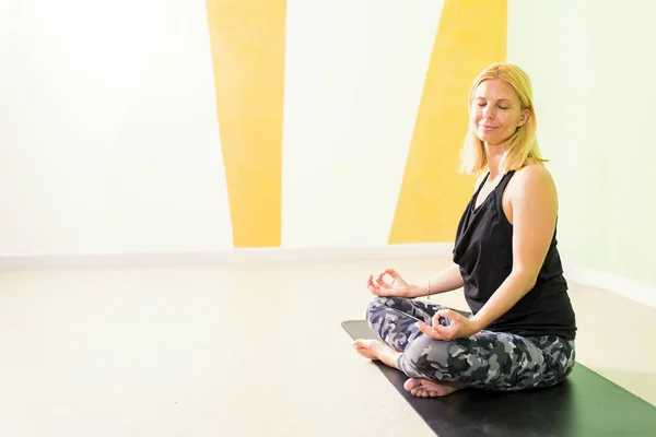 Schöne junge Frau sitzt in Yogaposition und meditiert — Stockfoto