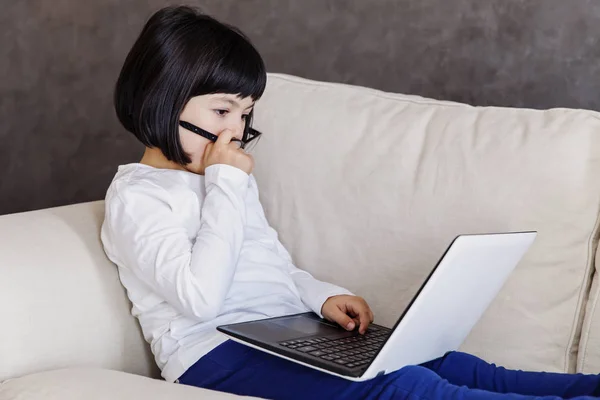 Dziewczynka w ubranie za pomocą laptopa — Zdjęcie stockowe
