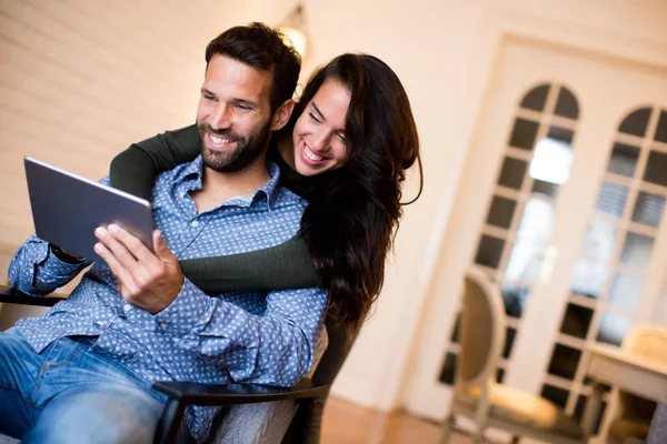 Jong (echt) paar zitten in de woonkamer en het gebruik van Tablet PC — Stockfoto