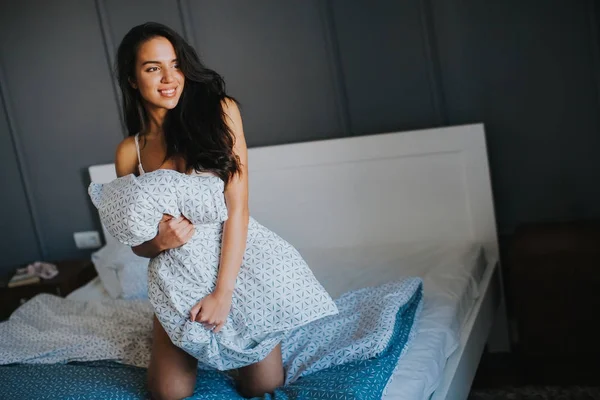 젊은 여자와 침대에 베개 — 스톡 사진