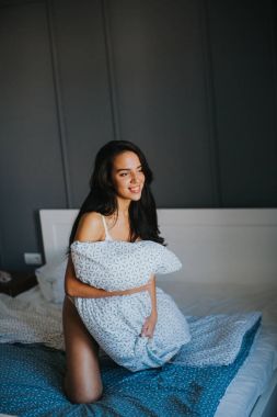 Genç kızla yatakta yastık