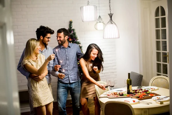 Glada kvinnor och män firar nyårsafton med gnistrar en — Stockfoto