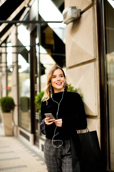 Mujer joven en la calle con teléfono móvil — Foto de Stock