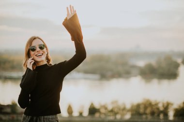 Cep telefonu tutan genç bir kadın.