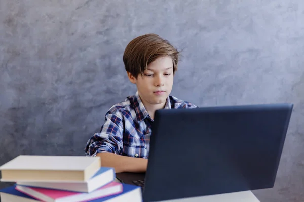 Милий хлопчик підліткового віку працює на ноутбуці вдома — стокове фото