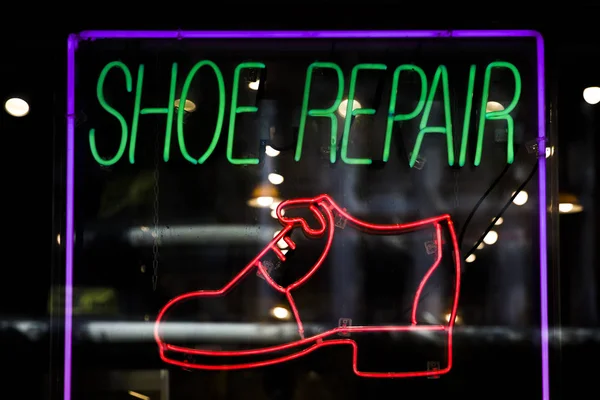 Neon sign colorful glowing bright shoe repair service — Stock Photo, Image
