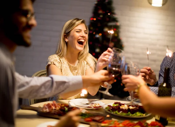 Jóvenes celebrando Año Nuevo y bebiendo vino tinto —  Fotos de Stock