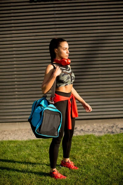 Ung kvinna med sportbag utomhus — Stockfoto