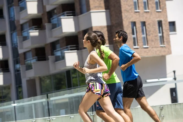 Dos jóvenes corriendo en un entorno urbano — Foto de Stock