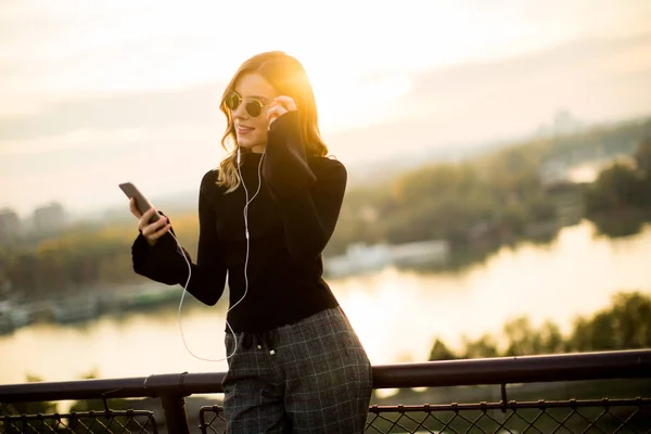 Mujer joven atractiva con teléfono móvil al aire libre — Foto de Stock