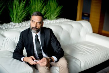 Yakışıklı işadamı cep telefonundan yazarak.