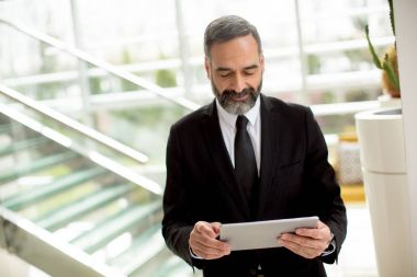 Yakışıklı zarif ciddi Kafkas işadamı tablet ile