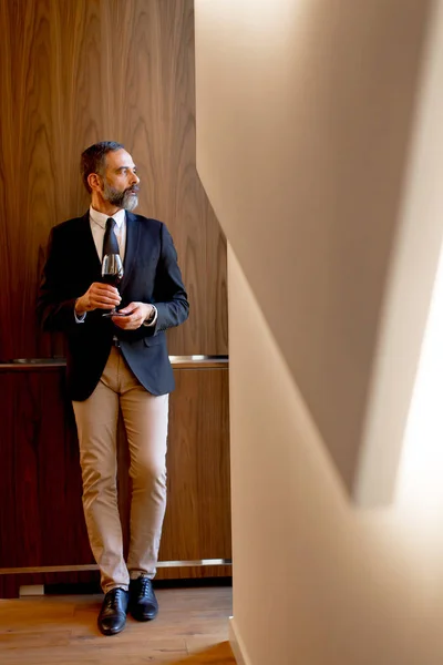 Handsome elegant businessman drinking red wine — Stock Photo, Image