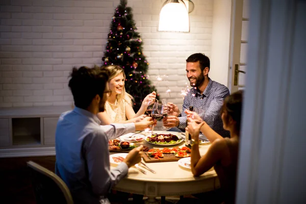 Jóvenes celebrando Año Nuevo y bebiendo vino tinto —  Fotos de Stock