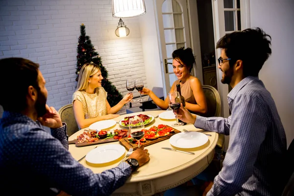 Giovani che festeggiano il nuovo anno e bevono vino rosso — Foto Stock