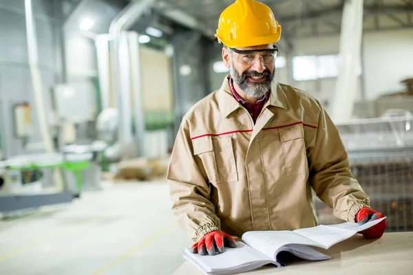 Ingeniero mirando el plan en la fábrica — Foto de Stock