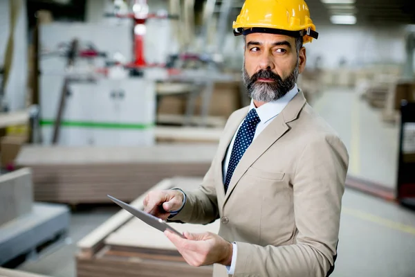 Middelbare leeftijd zakenman met digitale ta in fabriek — Stockfoto