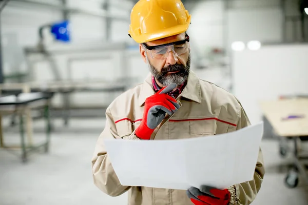 Ingenjören tittar på planen i fabriken — Stockfoto