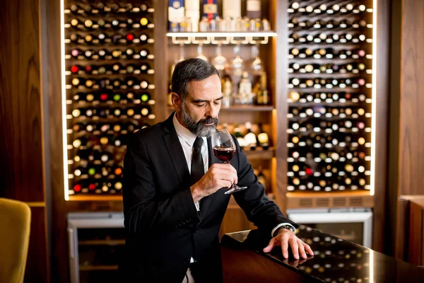 Portrait of handsome elegant businessman drinking red wine