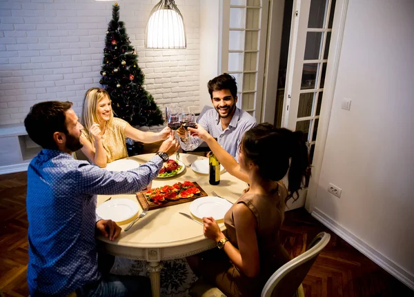 Jovens comemorando Ano Novo e bebendo vinho tinto — Fotografia de Stock