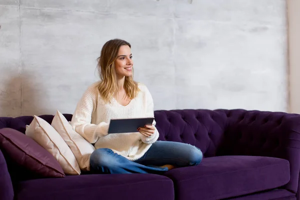 Young woman with tablet on sofa — Stock Photo, Image