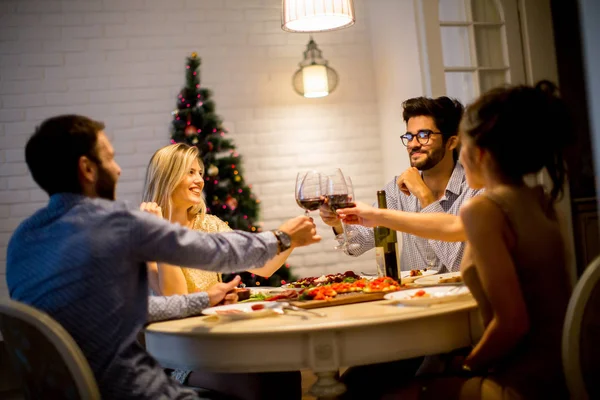 Jóvenes celebrando Año Nuevo y bebiendo vino tinto —  Fotos de Stock