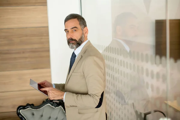 Middle aged  businessman with tablet in office — Stock Photo, Image